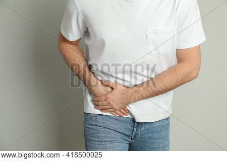 Man Suffering From Acute Appendicitis On Light Grey Background, Closeup