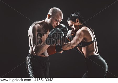 Shirtless Woman Exercising With Trainer At Boxing And Self Defen