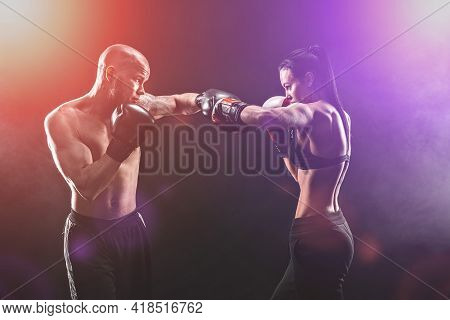 Shirtless Woman Exercising With Trainer At Boxing And Self Defen