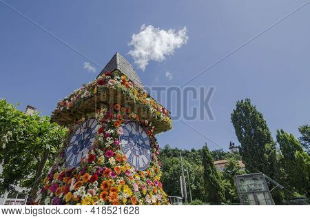 The Famous Clock Tower, One Of The City Of Graz Attractions, Made Of Flowers And The Real Clock Towe