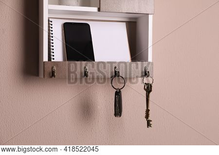 Wooden Hanger For Keys With Different Stuff On Color Wall