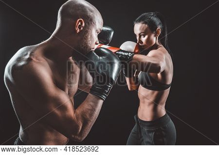 Shirtless Woman Exercising With Trainer At Boxing And Self Defen