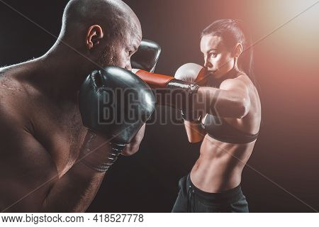 Shirtless Woman Exercising With Trainer At Boxing And Self Defen
