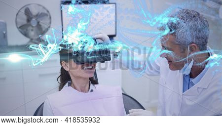 Composition of blue light trails over male doctor with smiling female patient wearing vr headset. global connection, virtual reality and technology concept digitally generated image.