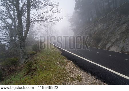 Curved Mountain Road On A Heavy Foggy Day With Very Low Visibility. Morcuera, Spain.