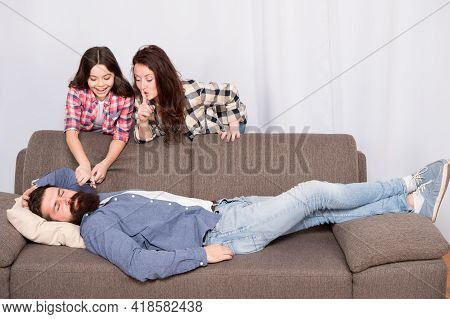 Family Prank. Little Girl With Mother Cut Fathers Beard. Happy Family At Home. Bearded Man Relax On 