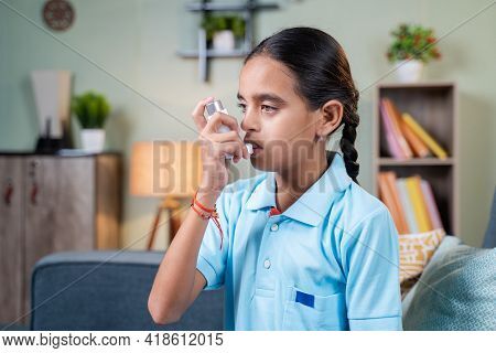 Side View Young Girl Kid Using Asthma Medication Inhaler After Taking Deep Breath - Concept Of Asthm