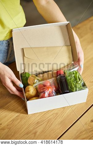 Woman Put On The Table Food Box Meal Kit Of Fresh Ingredients Order From A Meal Kit Company