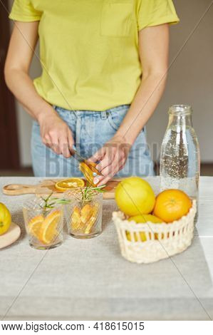 Female Hand Cut Orange, Woman Preparing, Making Citrus And Rosemary Fresh Lemonade