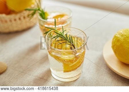 Citrus And Rosemary Fresh Lemonade In Glass On A White Table At Home