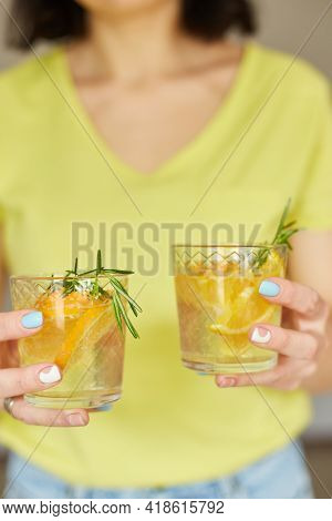Female Woman Hand Hold Two Glasses Of Citrus Orange And Rosemary Fresh Lemonade