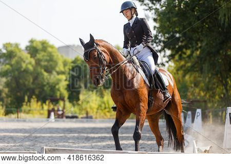 Young Girl Riding Horse At Dressage Advanced Test