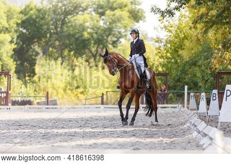 Young Girl Riding Horse At Dressage Advanced Test
