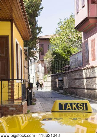 Yellow Taxi Cab Roof Sign With Taksi Turkish Word. Auto Was Parking On The Narrow Old Antalya Street