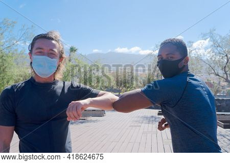 Covid-19 Pandemia Greeting With Elbows Bump Of Afro American Man And Caucsian Man