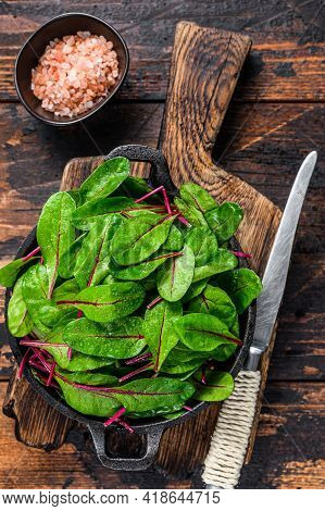 Fresh Raw Chard Leaves, Mangold, Swiss Chard In A Pan. Dark Wooden Background. Top View