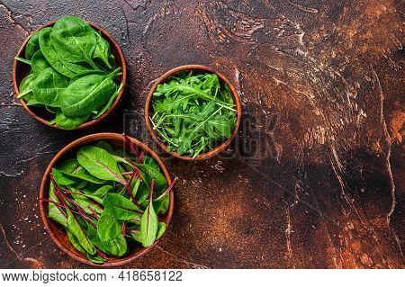 Mix Salad Leafs, Arugula, Spinach And Swiis Chard In Wooden Bowls. Dark Background. Top View. Copy S