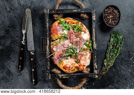 Italian Pizza With Prosciutto Parma Ham, Arugula Salad And Cheese In A Rustic Wooden Tray. Black Bac