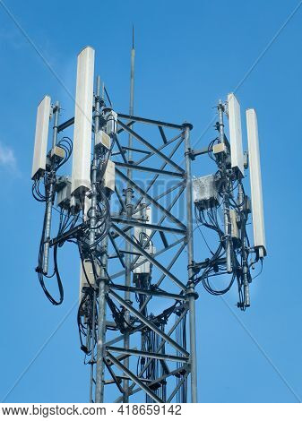 5g Tower Of Cellular Communication. Telecommunication Tower Against The Blue Sky With Clouds.