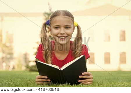 Open Your Imagination, Read. Happy Kid Read Book On Green Grass. Developing Imagination. Childhood I