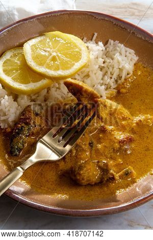African Chicken Curry Also Known As Kuku Paka, Served With Rice And Sliced Lemon