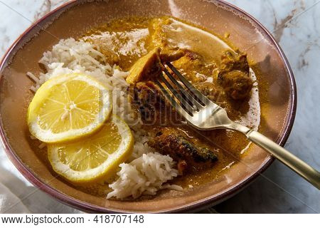 African Chicken Curry Also Known As Kuku Paka, Served With Rice And Sliced Lemon