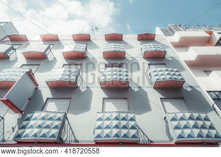 View From The Bottom Of A Bluish Dwelling House Facade With A Regular Structure Of Small Rectangular