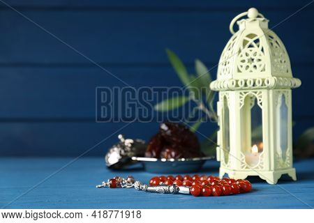 Arabic Lantern And Misbaha On Light Blue Wooden Table. Space For Text