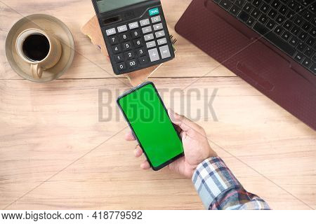 Top View Of Man Hand Using Smart Phone On Office Desk