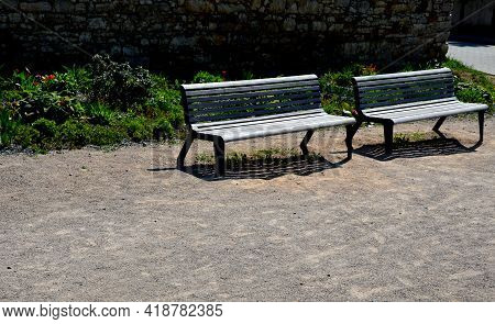 Perennial Bed Mulched With Gray Gravel In Front Of A Limestone Stone Wall In A Square With Benches W