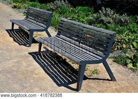 Perennial Bed Mulched With Gray Gravel In Front Of A Limestone Stone Wall In A Square With Benches W