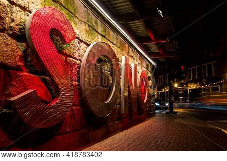 NORWALK, CT, USA - APRIL 24, 2021: SONO - South Norwalk sign under railroad bridge on Washington Street  with evening lights