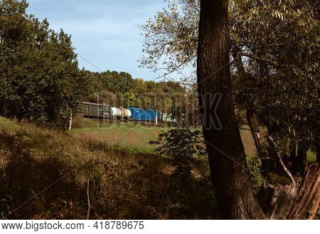 Old Ukrainian Train With Tank Wagon Ride At Railway In Forest Between Trees, Carriage Transportation
