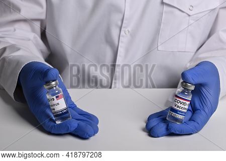 Doctor Shows American And Russian Covid Vaccine Phials. Drugstore Man Offers Inoculation Against Cov