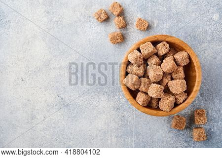 Cane Sugar Cube In Bamboo Bowl On Gray Table Concrete Background. Top View.