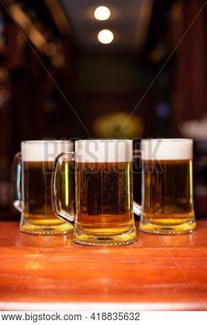 Pouring Beer Standing At The Bar Counter. Toasting Large Craft Beer In Pub