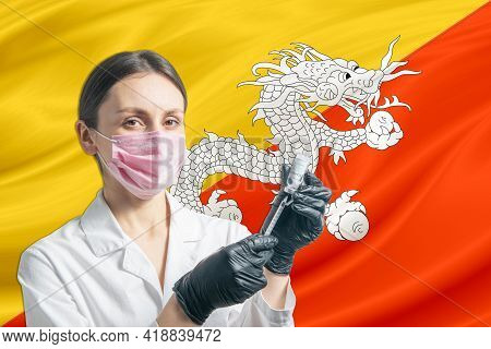 Girl Doctor Prepares Vaccination Against The Background Of The Butane Flag. Vaccination Concept Buta