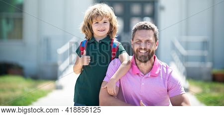 American Father And Son Walking Trough School Park. Thumbs Up Sign. Funny Face.