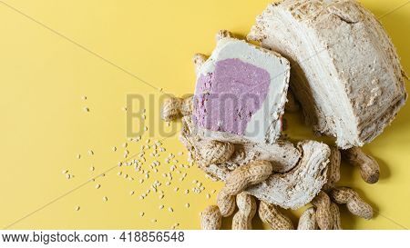 Peanut And Sesame Halva With Decoration In The Form Of Peanuts And Sesame Seeds On A Yellow Backgrou