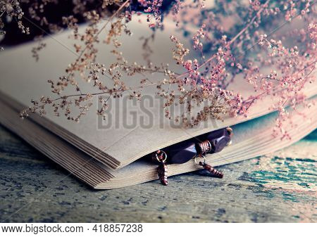 Brurred Dry Flowers On Vintage Notepad And Wooden Table. Retro Style, Vintage Toned