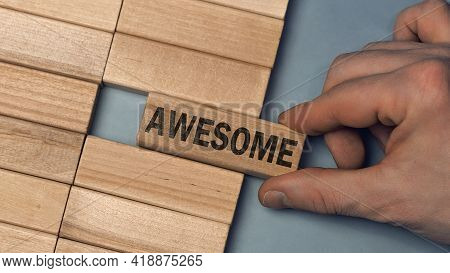 Awesome Word Concept. Close-up Wooden Piece Blocks On The Table. Top View