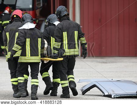Group Of Firefighters While Rescuing The Injured With A Stretcher After The Road Accident