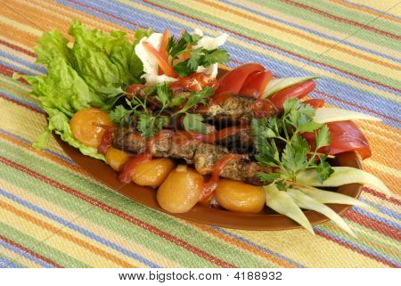Toasted Meat With Vegetables On A Striped Tablecloth