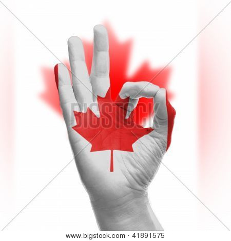 Mão sinal Ok com a bandeira canadense