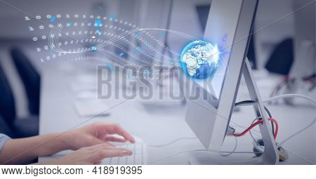 Graphic of world and binar code wave over desk with row of monitors. global technology, data processing and digital interface concept digitally generated image.
