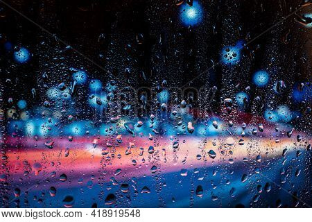 City View Through A Window On A Rainy Night,rain Drops On Window With Road Light Bokeh. Rainy Days.