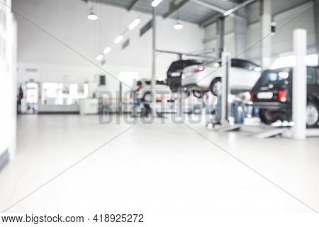 Car Repair Service In Defocus, Industrial Background. Cars On Lifts, Transport Service Area, The Mec