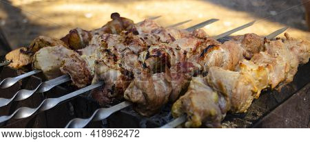 Shashlik Or Shish Kebab Preparing On Barbecue Grill Over Hot Charcoal. Grilled Pieces Of Pork Meat O