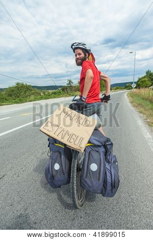 MOSTAR, BOSNIA - AUGUST 14: Young cyclist touring from Madrid to Istanbul on August 14, 2012 near Mostar, Bosnia. A growing number of eco-travellers tour by bike to lessen their carbon footprint.
