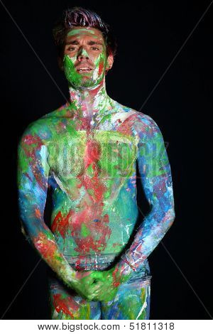 Man with naked torso covered in paint in the studio